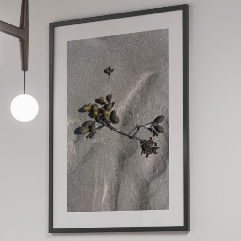 Rubrikfoto Momentaufnahmen Schwarzer Tisch mit zwei Stühlen und einer gerahmten Momentaufnahme an der Wand.